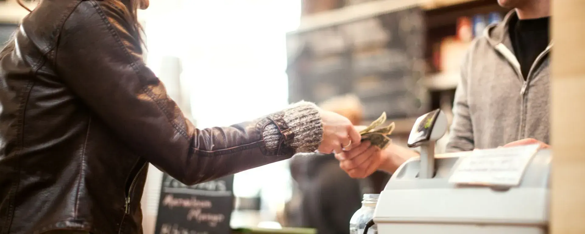 Women checking out at counter with cash