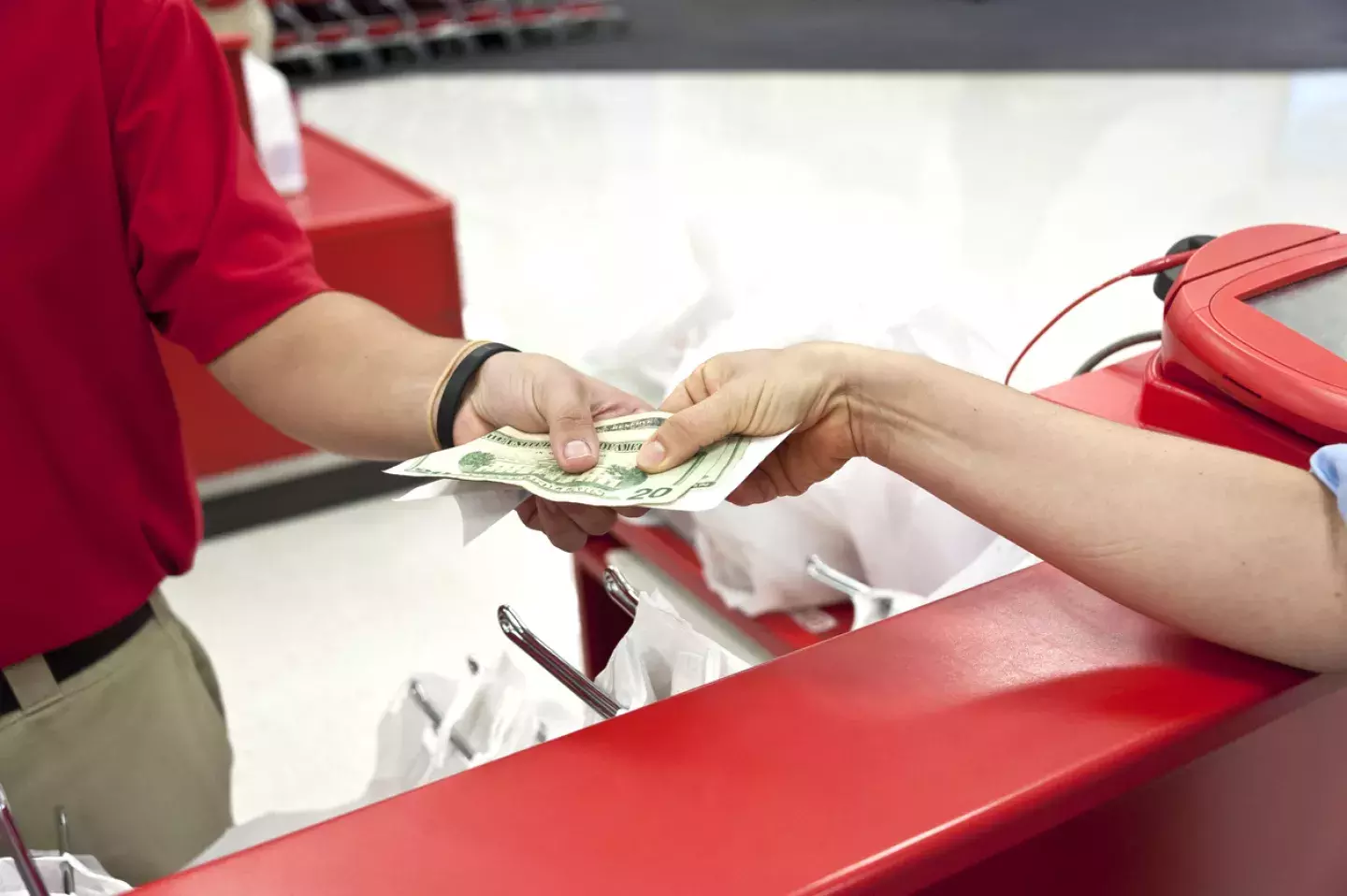 Customer handing employee cash in retail store