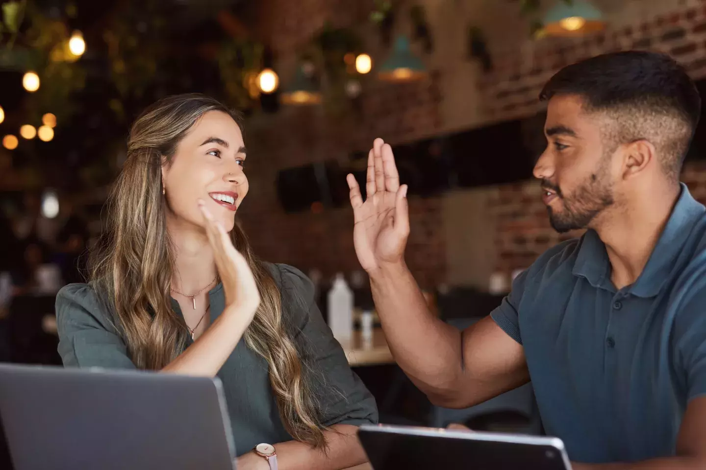 Man and woman in restaurant high fiving